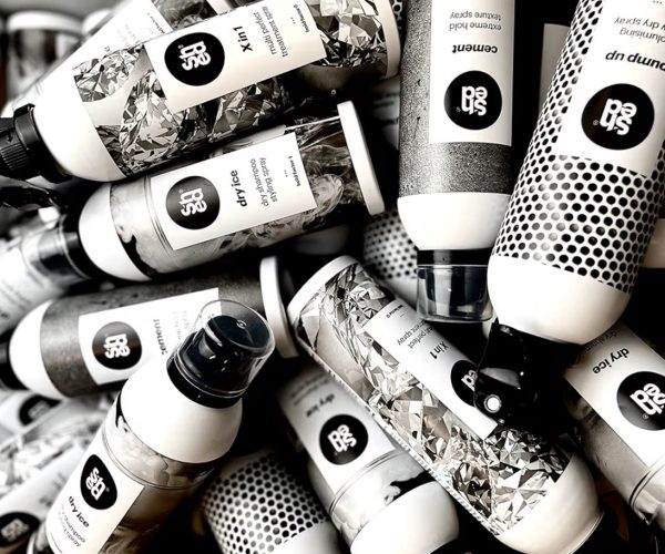 Serenity Emporium Hair Salon Cheadle - Summer Hair Care: How to Keep Your Blonde Looking Expensive All Summer Long Young pretty cheerful blond woman in swimsuit wearing white shirt and hat happily looking in camera with sea on background